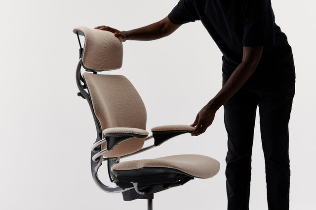 Person adjusting ergonomic chair settings